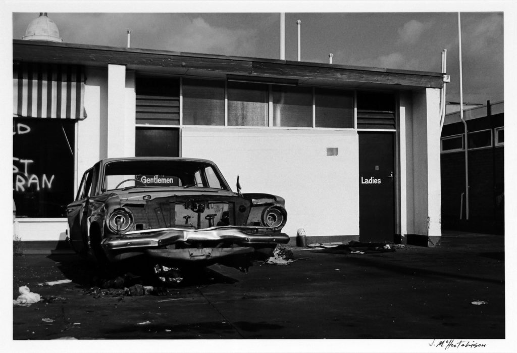 Wrecked car outside service station toilets