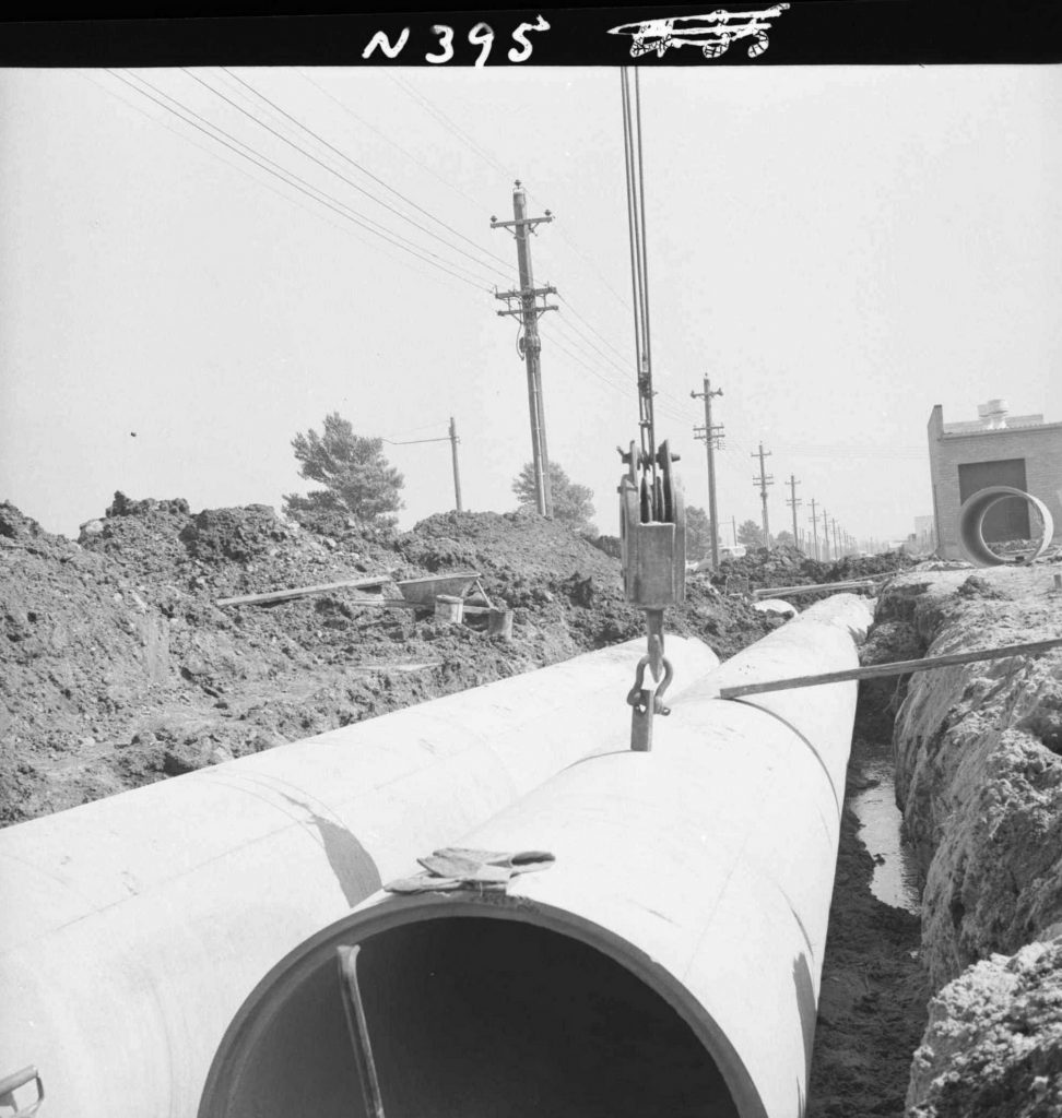 N395 Image showing laying of a 16′ length, 39″ diameter reinforced concrete pipe during drain construction on Footscray Road