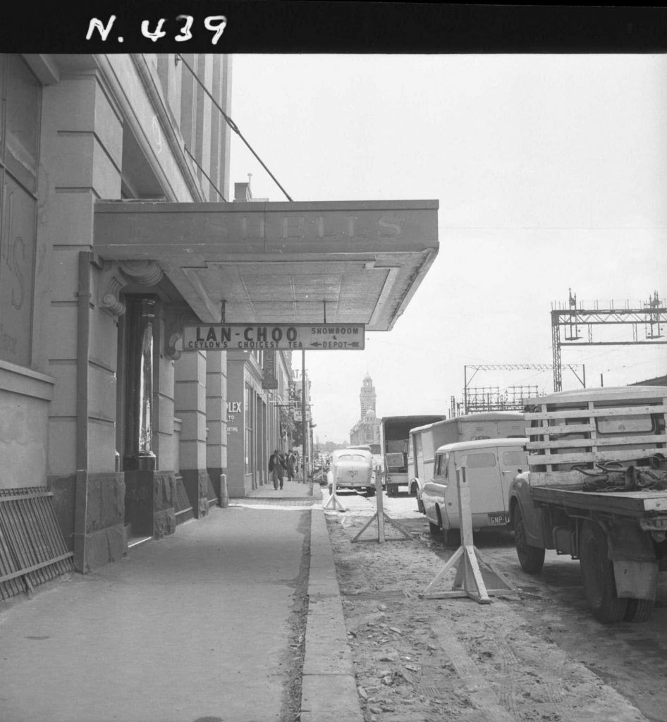 N439 Image showing the canopy of Bushells overhanging the new line of kerb, during construction of the Flinders Street overpass