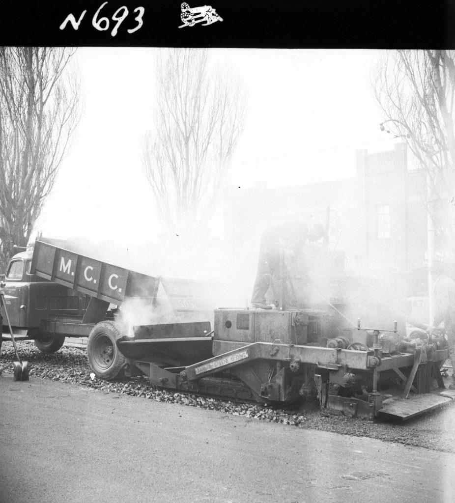 N693 Image showing a Barber-Greene machine receiving a refill of hot mix asphalt