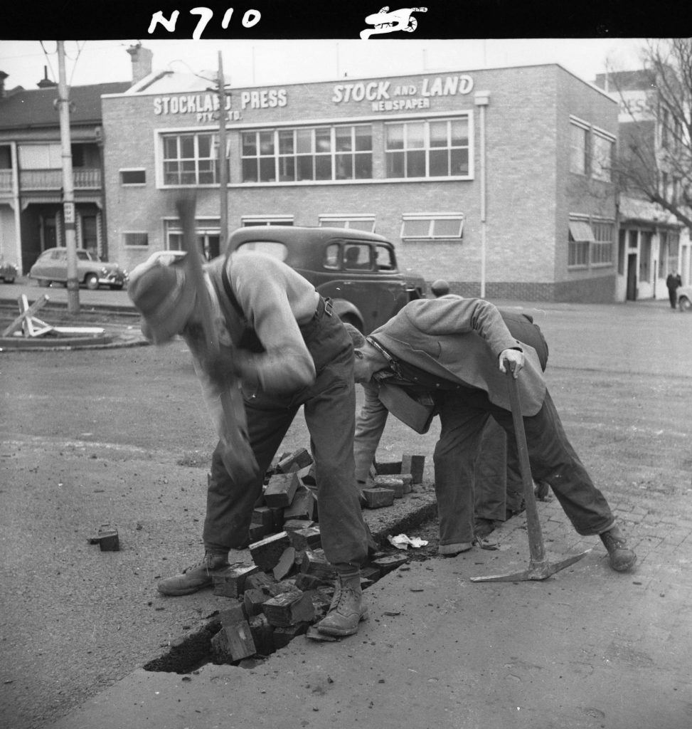 N710 Image showing a strip of wood block roadway being removed by picks