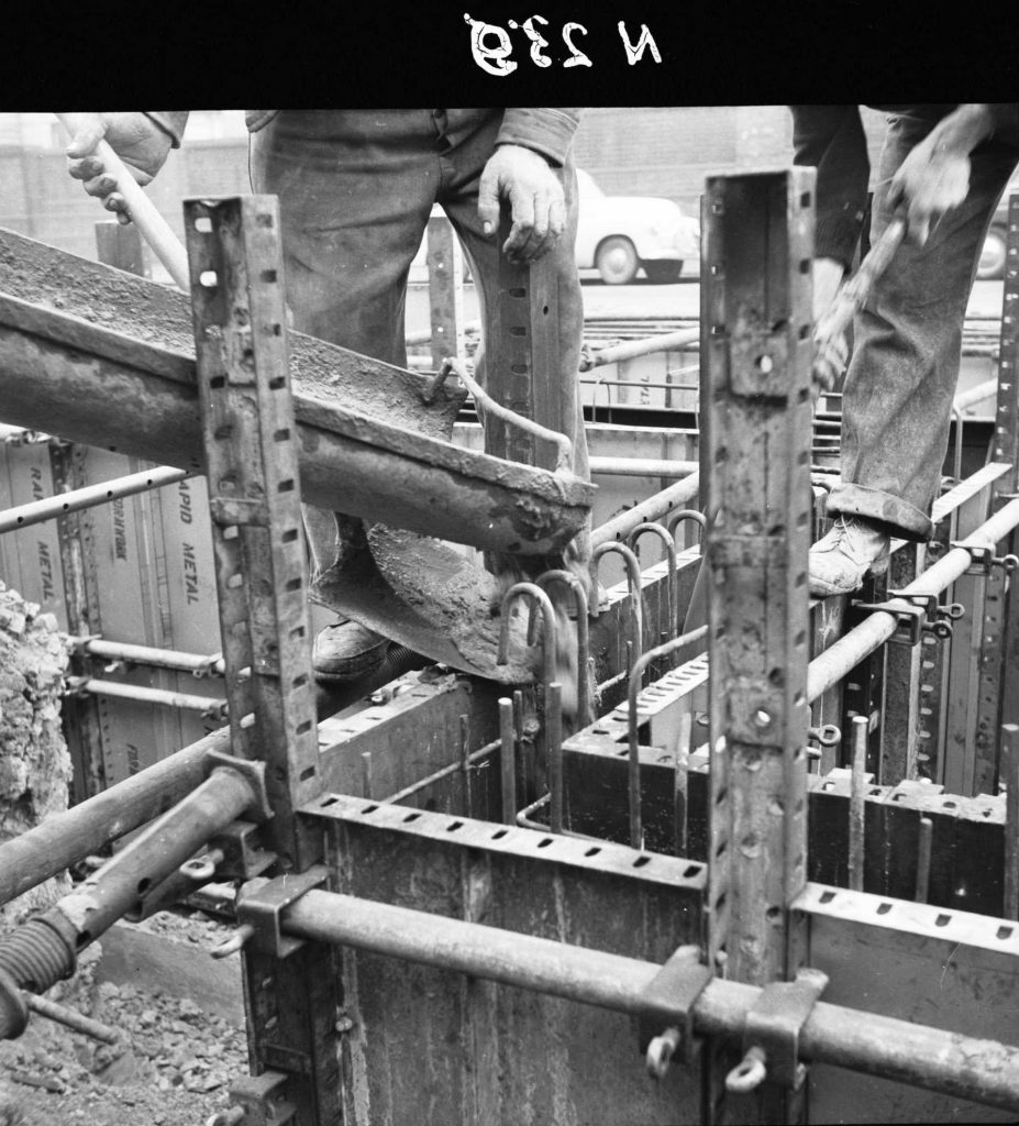 N239 Image showing a vibrator in operation with wall pour during construction of a weighbridge on Flinders Street