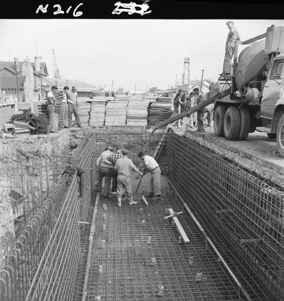 N216 Image showing the spreading and compacting of the first pour of floor slab, during construction of a weighbridge on Flinders Street