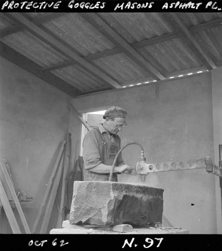 N97 Image showing a mason wearing protective goggles at a masons workshop on Green Street