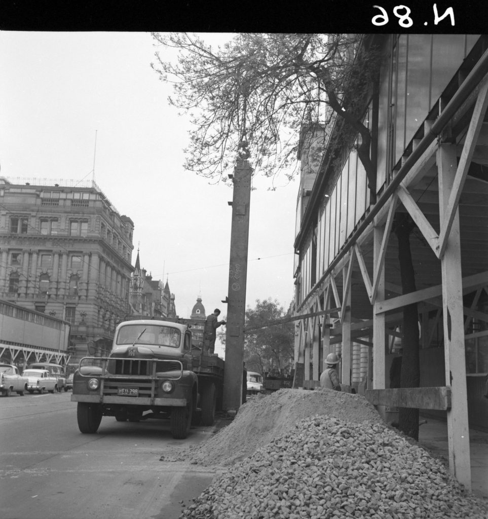 N86 Image showing hoardings and workers hoisting steel around the Royal Globe Insurance building on Collins Street