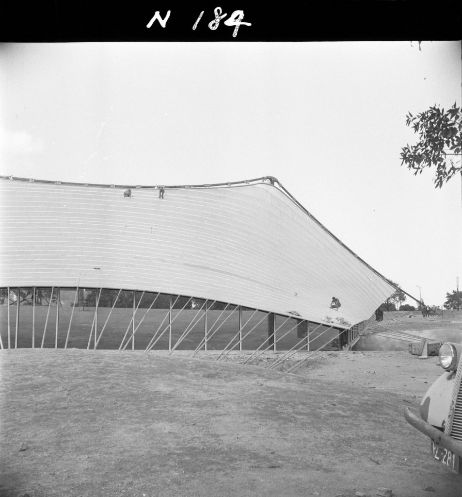 N184 Image showing sealing of roof joints and installation of glass during construction of the Sidney Myer Music Bowl