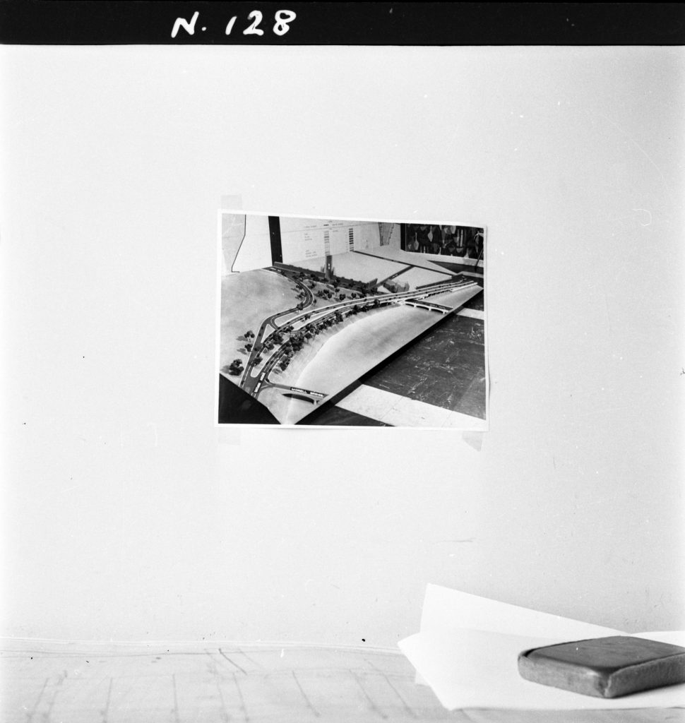 N128 Image showing a photo of the model for Moreshead Overpass, hanging above a desk