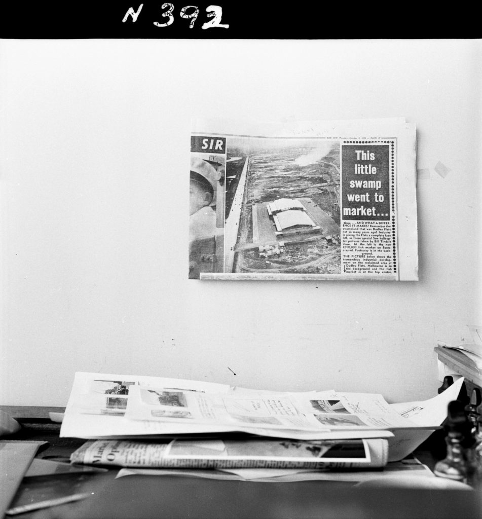 N392 Image showing a newpaper clipping about the new Fish Market on Footscray Road, hanging above a desk