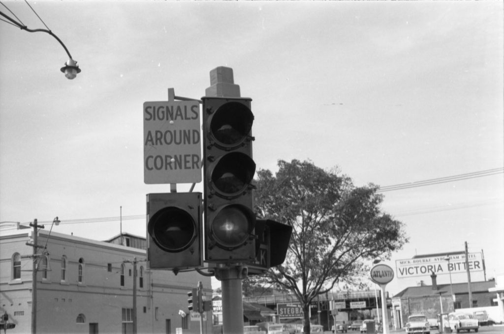 35A-34f Image of a traffic light with a sign marked “signals around corner”