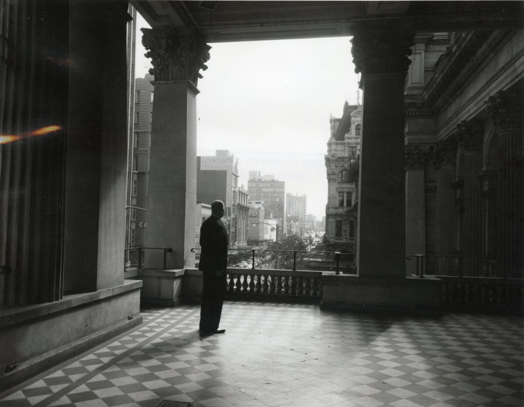 Image of a man on the upper level of Melbourne Town Hall’s portico